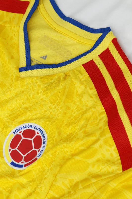 Close-up of a yellow colombian soccer jersey with red stripes.
