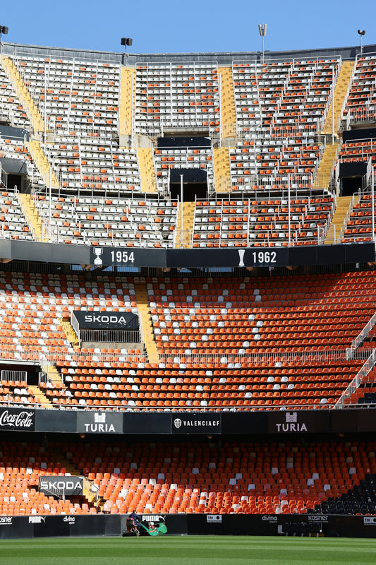 Empty stadium seats under a clear blue sky